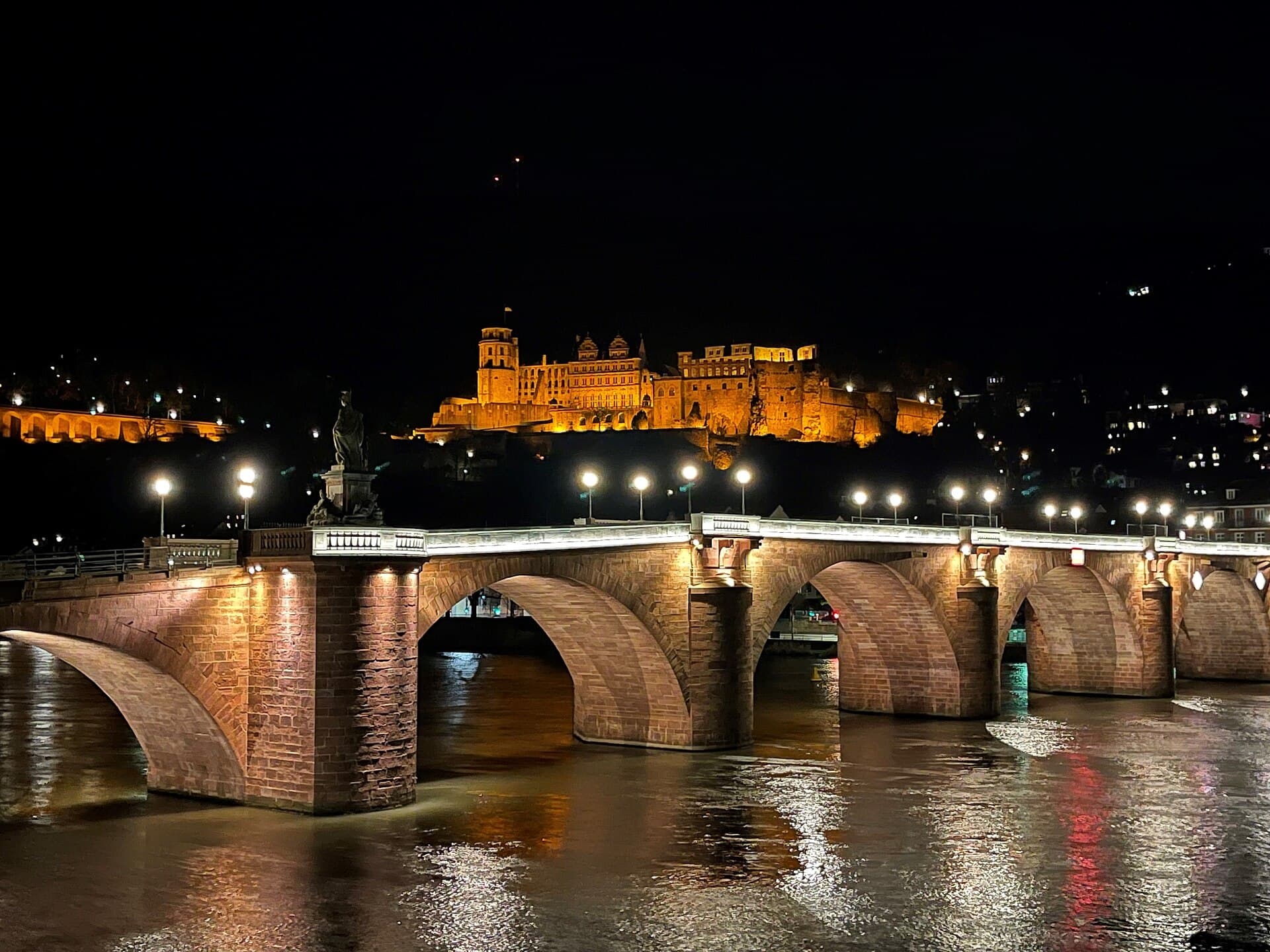 Heidelberg castle and old bridge glowing at night